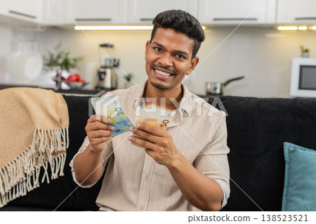 Indian man counts euro cash happy makes money gesture plans dream purchase savings bonus invest plan Indian man counts euro cash happy makes money gesture plans dream purchase savings bonus invest plan 138523521