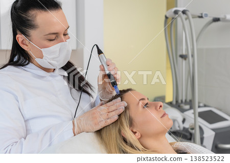 Trichologist doing woman improve hair growth procedure, dermapen microneedling, vitamin injections Trichologist doing woman improve hair growth procedure, dermapen microneedling, vitamin injections 138523522