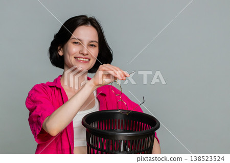 Young woman smiling removing eyeglasses throwing them away symbolizing vision correction and freedom Young woman smiling removing eyeglasses throwing them away symbolizing vision correction and freedom 138523524