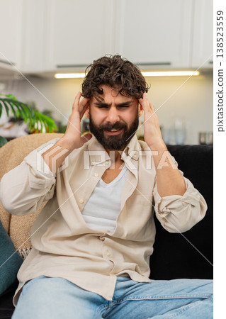 Indian man pressing fingers to temples suffering headache migraine pain stress worrying about health Indian man pressing fingers to temples suffering headache migraine pain stress worrying about health 138523559