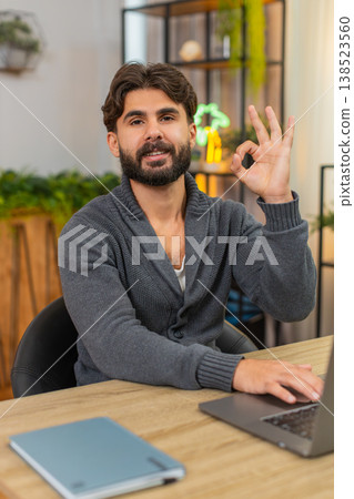 Indian man completes contract on laptop adds digital signature breathes relief shows approval sign Indian man completes contract on laptop adds digital signature breathes relief shows approval sign 138523560
