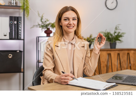 Businesswoman holds keys for new room signs contract paper smiles shows keychain starts new chapter Businesswoman holds keys for new room signs contract paper smiles shows keychain starts new chapter 138523581