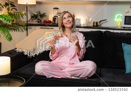 Woman counts money cash euros with smartphone plans budget notes check salary income saving record Woman counts money cash euros with smartphone plans budget notes check salary income saving record 138523592