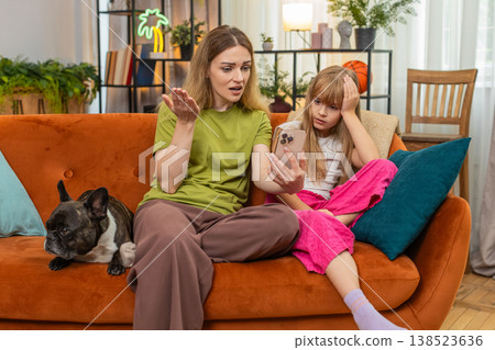 Mother daughter dog lose mobile game with smartphone shrug why gesture frown upset family reaction Mother daughter dog lose mobile game with smartphone shrug why gesture frown upset family reaction 138523636