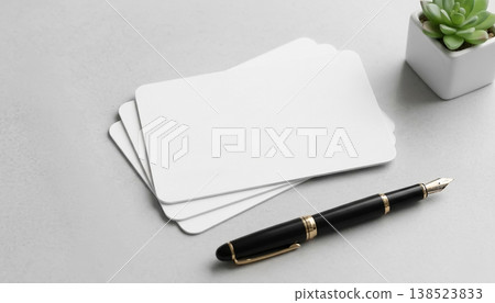 Stationery items with blank card stock and a fountain pen on a gray desk at an organized workspace Stationery items with blank card stock and a fountain pen on a gray desk at an organized workspace 138523833
