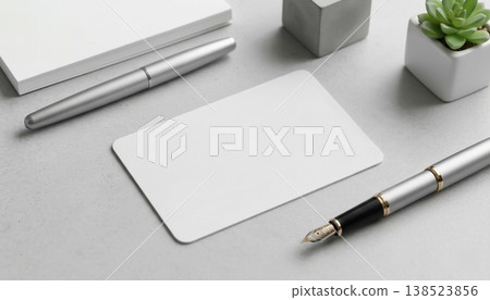 Blank business card and stationery on a desk beside a pen and a small plant Blank business card and stationery on a desk beside a pen and a small plant 138523856
