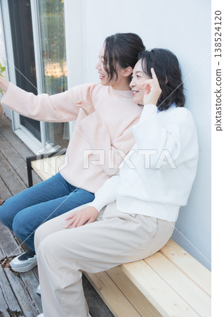 一幅母女親密合影，她們在復古風格的陽台上用智慧型手機自拍。 138524120