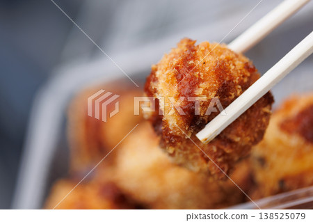 用筷子夾著炸章魚燒 138525079