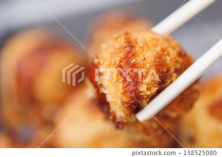 用筷子夾著炸章魚燒 138525080