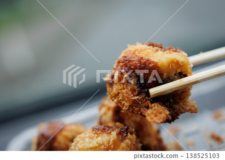 Fried takoyaki held with chopsticks Fried takoyaki held with chopsticks 138525103