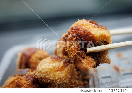 Fried takoyaki held with chopsticks Fried takoyaki held with chopsticks 138525104