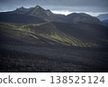 Volcanic landscape with mountains covered by black sand and green lichen, Iceland 138525124