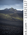 Vertical shot of volcanic landscape with mountains covered by black sand and green lichen, Iceland 138525127
