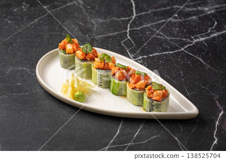 Sushi rolls wrapped in cucumber with spicy topping Sushi rolls wrapped in cucumber with spicy topping 138525704