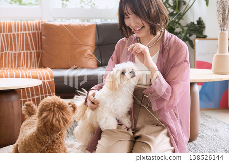 A woman gives treats to her Toy Poodle and Maltese: Dog training and pet life A woman gives treats to her Toy Poodle and Maltese: Dog training and pet life 138526144