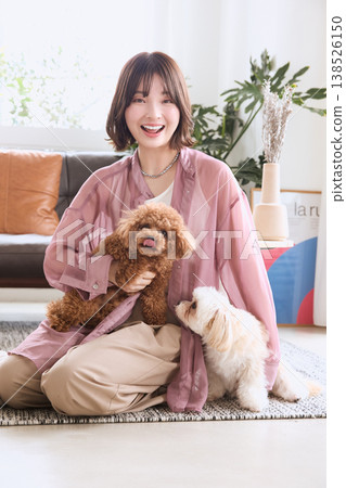 A woman giving treats to her toy poodle and Maltese; life with multiple dogs. A woman giving treats to her toy poodle and Maltese; life with multiple dogs. 138526150