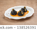 Black khinkali dumplings with sauce on plate 138526391