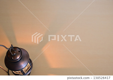 桌子上放著一盞燃著火焰的燈籠。 桌子上放著一盞燃著火焰的燈籠。 138526417