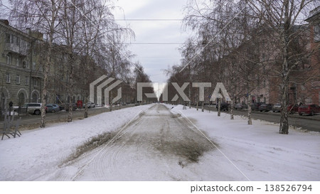 March 22 2026 Barnaul Russia alley on Leninsky Avenue from October Square covered in snow cold early spring cityscape with trees pedestrian path urban environment and winter atmosphere. 138526794