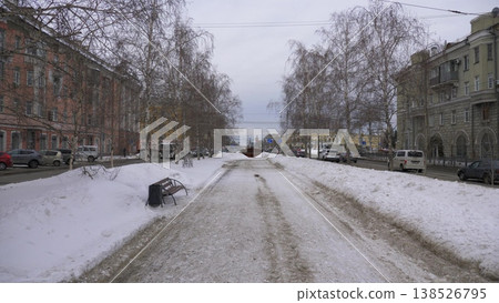 March 22 2026 Barnaul Russia alley on Leninsky Avenue from October Square covered in snow cold early spring cityscape with trees pedestrian path urban environment and winter atmosphere. 138526795