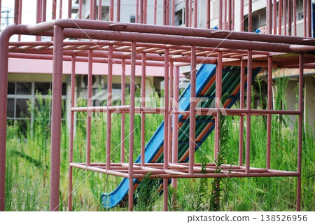A rusty jungle gym and a view of a housing complex. 138526956