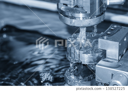 High-precision wire cut EDM machine processing complex mold parts in a modern industrial facility. High-precision wire cut EDM machine processing complex mold parts in a modern industrial facility. 138527225