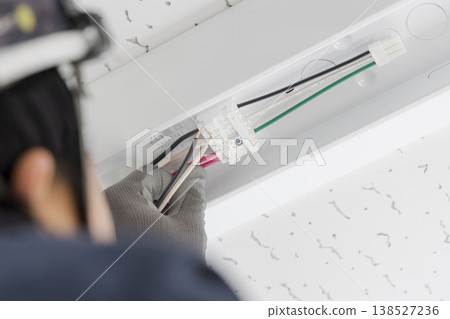 An electrician installing and wiring ceiling lights; a scene of maintenance and LED replacement work. (Image) An electrician installing and wiring ceiling lights; a scene of maintenance and LED replacement work. (Image) 138527236