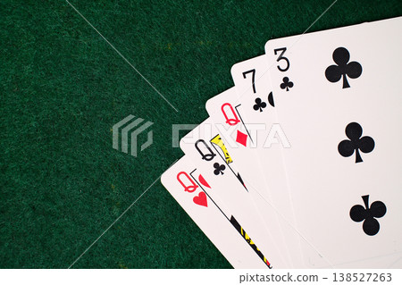3 Of A Kind Combination Playing cards arranged on dark green felt casino gambling table closeup detail 3 Of A Kind Combination Playing cards arranged on dark green felt casino gambling table closeup detail 138527263