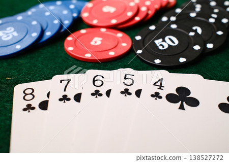 Straight Flush Combination Playing cards spread beside casino chips on green felt gambling table Straight Flush Combination Playing cards spread beside casino chips on green felt gambling table 138527272
