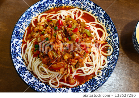 Authentic Uyghur suiru lagman noodle dish with rich meat tomato sauce in blue patterned bowl top view Authentic Uyghur suiru lagman noodle dish with rich meat tomato sauce in blue patterned bowl top view 138527280