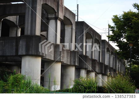 Underneath the elevated structure, massive concrete bridge piers line the area. Underneath the elevated structure, massive concrete bridge piers line the area. 138527383