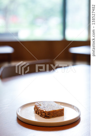 a piece of banana bread cake on table by the window. 138527482