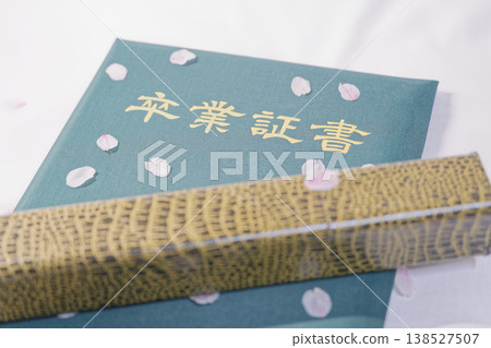 A graduation certificate topped with cherry blossom petals and the image of a new life. 138527507