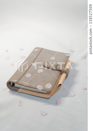A notebook with falling cherry blossom petals and the image of a new life. A notebook with falling cherry blossom petals and the image of a new life. 138527509