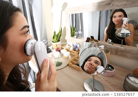 Teen Girl Using Facial Radiofrequency Device at Mirror Teen Girl Using Facial Radiofrequency Device at Mirror 138527657