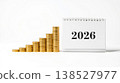 Stacked gold coins with a calendar displaying the year 2026 on a white background 138527977