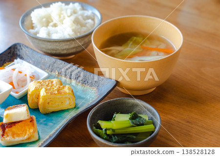 特寫鏡頭展現了一份日式早餐，包括配料豐富的味噌湯和玉子燒（捲蛋餅）。 138528128