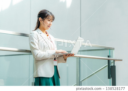 Business woman standing with a laptop Business woman standing with a laptop 138528177