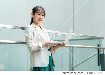 Business woman standing with a laptop Business woman standing with a laptop 138528178