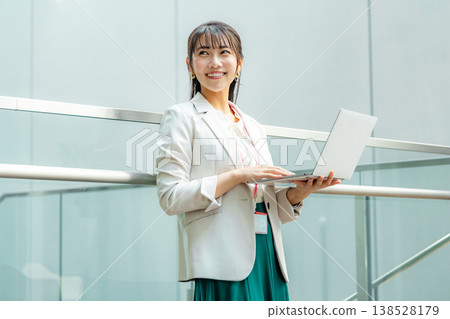 Business woman standing with a laptop 138528179