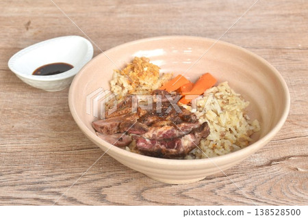 grilled slice beef meat on fried rice and carrot on bowl dipping Thai spicy chili with tamarind sauce 138528500