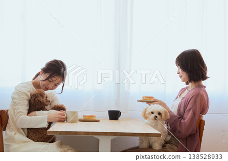 兩位女士帶著她們的玩具貴賓犬和馬爾濟斯犬在咖啡館享受時光：與寵物相伴的生活方式 138528933