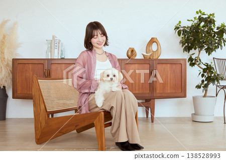 A Maltese dog and a woman living in a natural interior: a pet life. 138528993