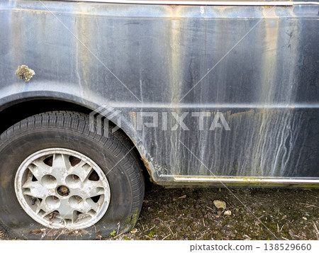 A rusted vintage car being abandoned on a street with flat tires and rusty bodywork A rusted vintage car being abandoned on a street with flat tires and rusty bodywork 138529660
