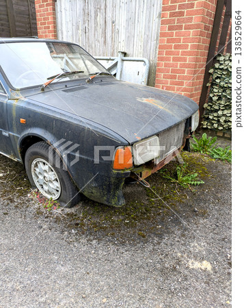 A rusted vintage car being abandoned on a street with flat tires and rusty bodywork A rusted vintage car being abandoned on a street with flat tires and rusty bodywork 138529664