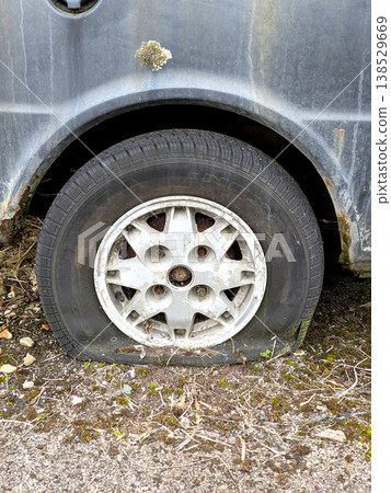 A rusted vintage car being abandoned on a street with flat tires and rusty bodywork A rusted vintage car being abandoned on a street with flat tires and rusty bodywork 138529669