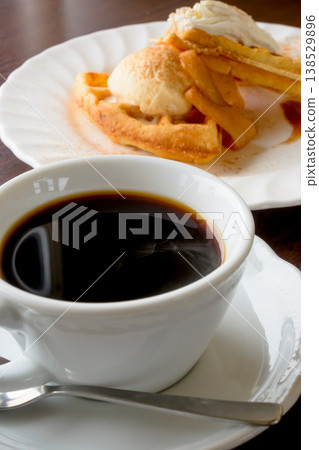 Coffee and waffles: A sweet treat to enjoy at a cafe. Coffee and waffles: A sweet treat to enjoy at a cafe. 138529896
