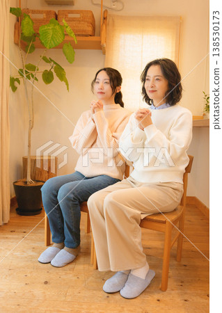 A mother and daughter pray for the deceased at home. A mother and daughter pray for the deceased at home. 138530173