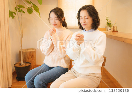 一對母女在家中為逝者祈禱。 一對母女在家中為逝者祈禱。 138530186