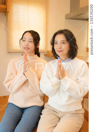一對母女在家中為逝者祈禱。 一對母女在家中為逝者祈禱。 138530200
